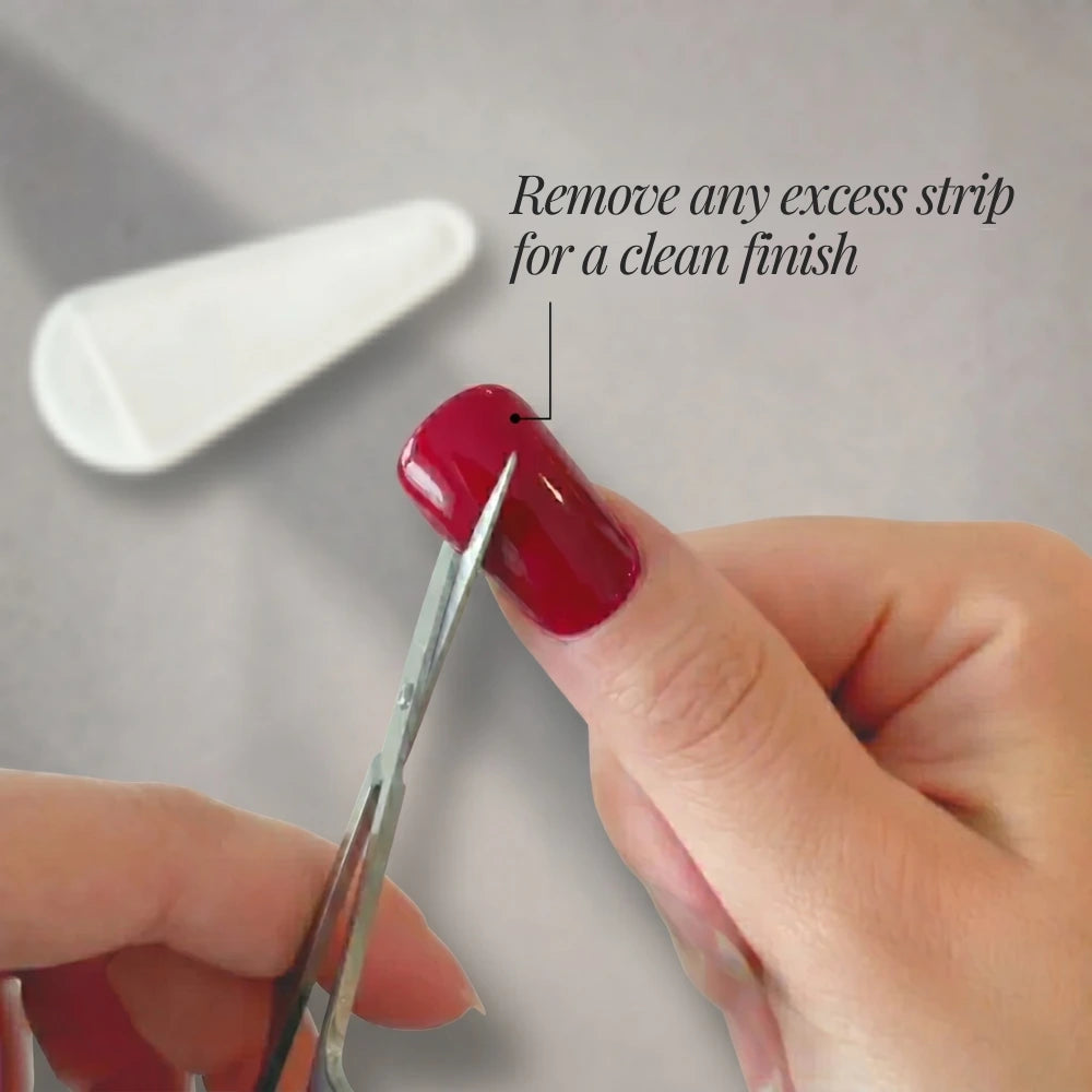 Person using tweezers to remove excess nail strip on a gray background
