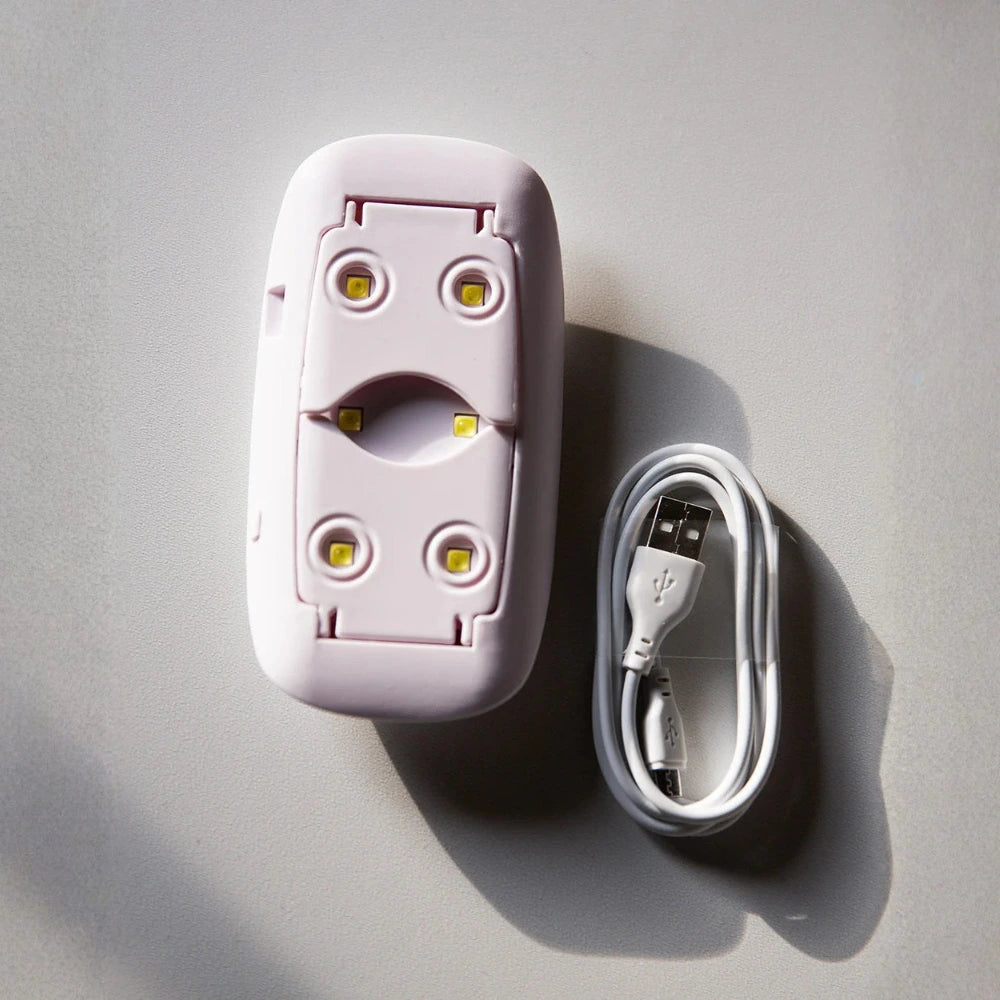White electronic device with LED lights and a USB cable on a gray background